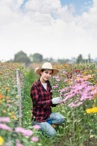 Portrait of young woman with pink flowers in garden