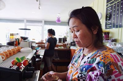 Woman looking away while sitting in kitchen