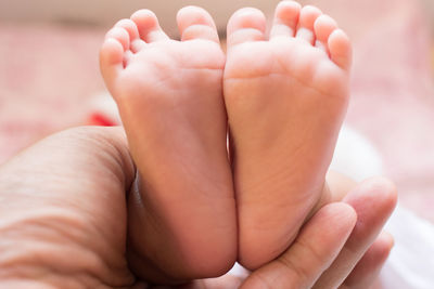 Close-up of hand holding baby feet