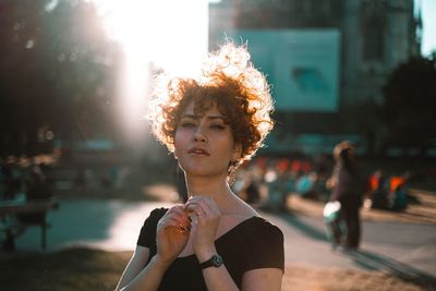 Portrait of woman holding ice cream in city