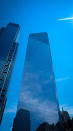 Low angle view of modern buildings against blue sky