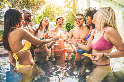 Cheerful friends in swimming pool during social gathering