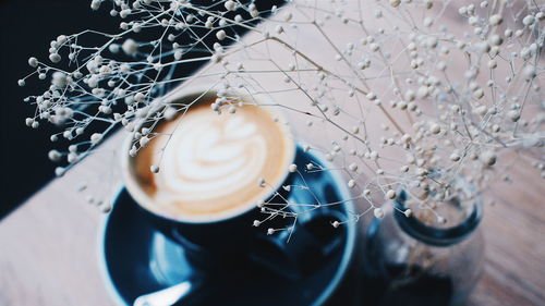 High angle view of coffee cup with vase on table