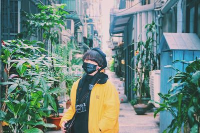 Man wearing sunglasses standing by plants in city