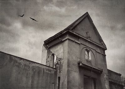 Low angle view of building against cloudy sky