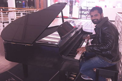 Side view portrait of smiling man playing piano