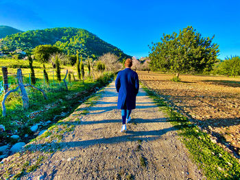 Rear view of man walking on field