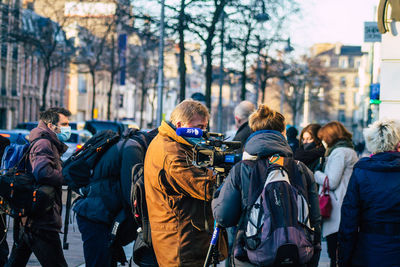 Rear view of people walking on street in city