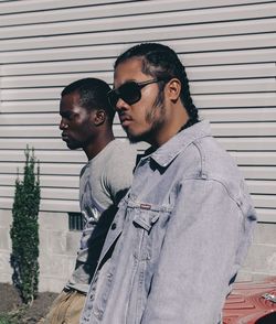 Young men standing against wall