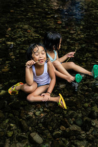 Full length of mother and daughter in water