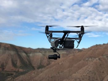 Drone flying against mountains and sky