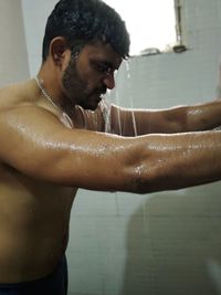 Side view of young man in bathroom