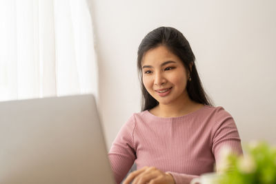 Young woman using laptop at home