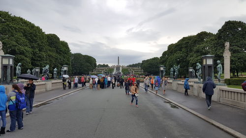 People walking on road against sky