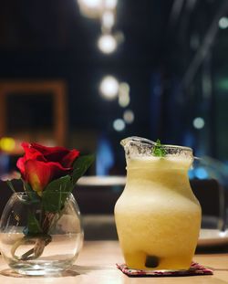 Close-up of rose in glass on table