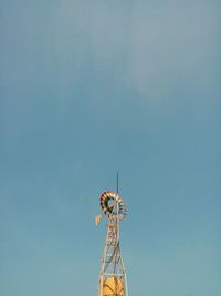 Low angle view of communications tower against blue sky