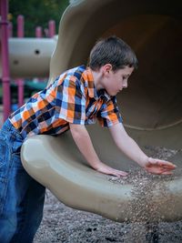 Boy cleaning slide at playground