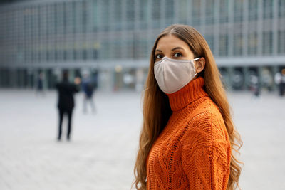 Portrait of woman wearing mask while standing in city