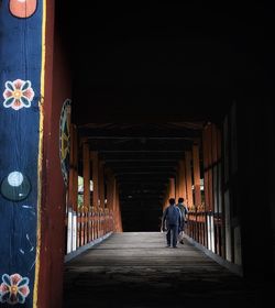 Rear view of man walking in corridor of building