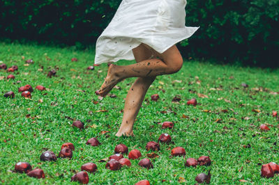 Low section of woman running on field