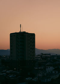 Silhouette buildings against clear sky during sunset