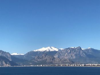 Scenic view of snowcapped mountains against clear blue sky