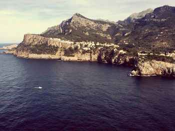 Scenic view of sea and mountains against sky