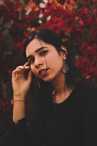 Portrait of young woman against trees