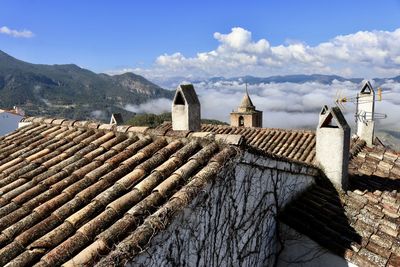 Buildings in town against cloudy sky