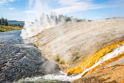 Scenic view of waterfall against sky