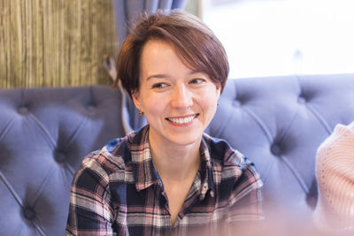 Portrait of smiling woman sitting on sofa