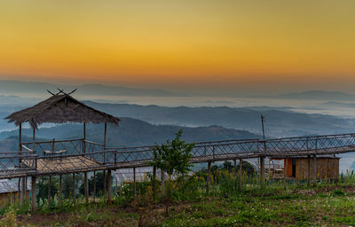 Lifeguard hut on land against sky during sunset