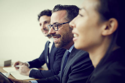 Smiling male and female financial colleagues sitting in office during meeting
