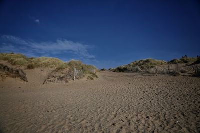 Scenic view of desert against blue sky