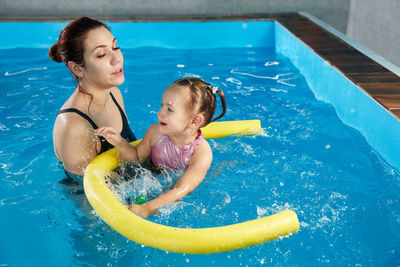 Portrait of young woman swimming in pool
