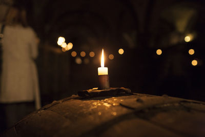 Close-up of illuminated candle in darkroom
