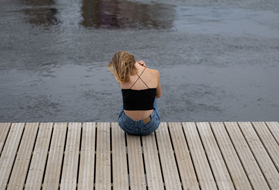 Young woman sitting on pier