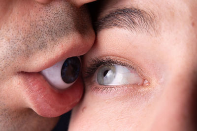 Woman looking at man with artificial eye in mouth