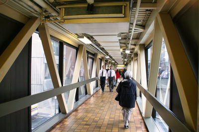 Rear view of people walking in corridor