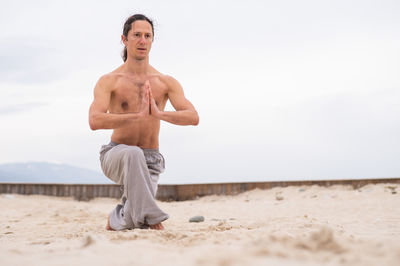 Shirtless man standing at beach