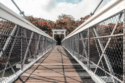 Empty footbridge against sky