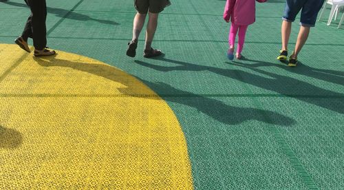 Low section of people walking on tiled floor