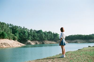 Full length of woman standing on lake