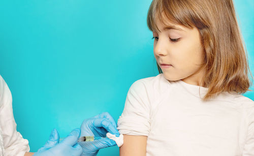 Girl taking vaccination from doctor