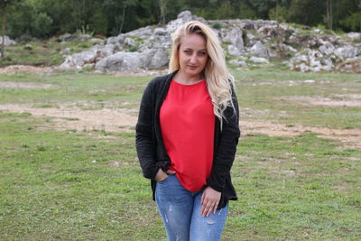 Portrait of smiling young woman standing on land