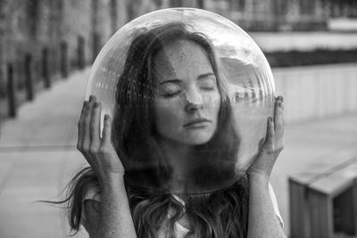 Young woman wearing glass helmet in head on sidewalk