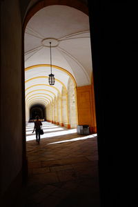 Rear view of silhouette woman walking in archway