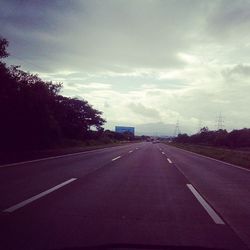 Empty road against cloudy sky