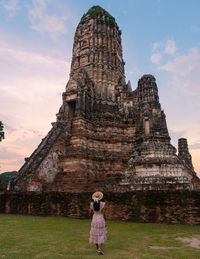 Rear view of woman standing on mountain against sky