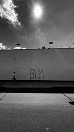 Man walking on road against sky